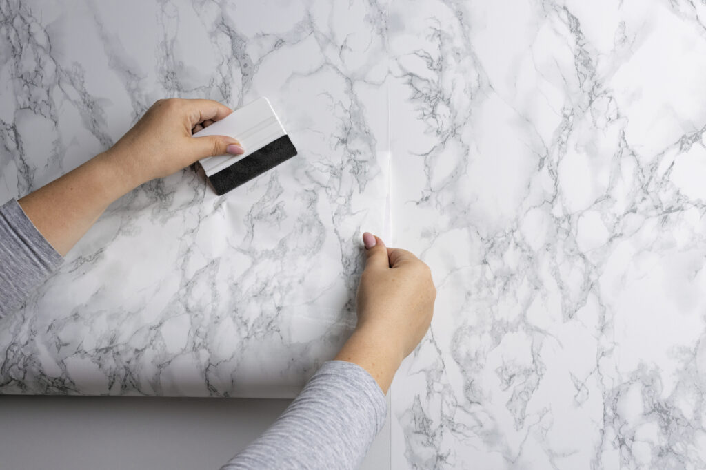 Poser un papier peint sans bulles : pose au mur avec brosse à maroufler