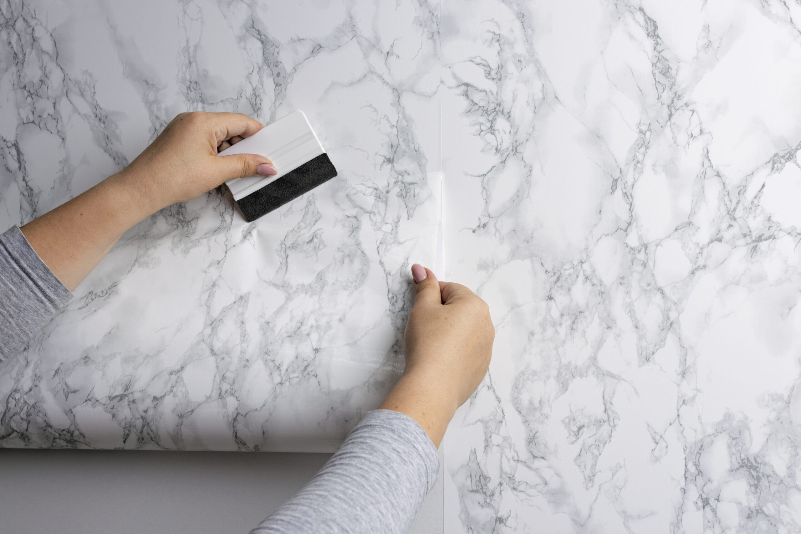 Poser un papier peint sans bulles : pose au mur avec brosse à maroufler